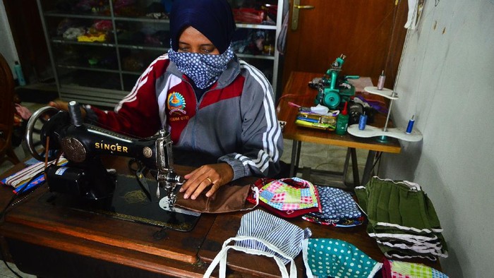 Relawan menunjukkan masker hasil produksinya di Gondangmanis, Kudus, Jawa Tengah, Senin (6/4/2020). Masker yang diproduksi dari bahan kain perca tersebut akan didistribusikan secara gratis kepada masyarakat yang membutuhkan guna mencegah penyebaran COVID-19. ANTARA FOTO/Yusuf Nugroho/wsj.