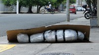 Jenazah terbungkus plastik dan ditutup kardus tergeletak di persimpangan jalan Maracaibo dan Buenos Aires, Guayaquil, Ekuador pada 6 April 2020. Francisco Macías/Getty Images/Getty Images.