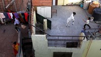 Ada anak-anak bermain layangan dari balkon rumahnya di Karachi, Pakistan. (REUTERS/Akhtar Soomro)