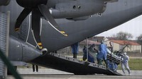 Petugas medis membawa pasien Corona menggunakan pesawat militer Airbus A400M di bandara Strasbourg, Prancis (29/3/2020).  Pesawat yang dibandrol dengan harga sekitar 100 juta dollar AS tersebut tidak banyak yang memiliki karena saking mahalnya biaya yang harus dikeluarkan. Kelebihannya dapat mendarat di runway pendek dan tidak mulus sehingga sangat mengakomodasi kebutuhan militer. Photo by FREDERICK FLORIN/AFP via Getty Images.
