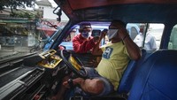Seperti sopir angkot yang tengah dipakaikan masker yang diberi secara cuma-cuma di Bogor ini. ANTARA FOTO/Yulius Satria Wijaya