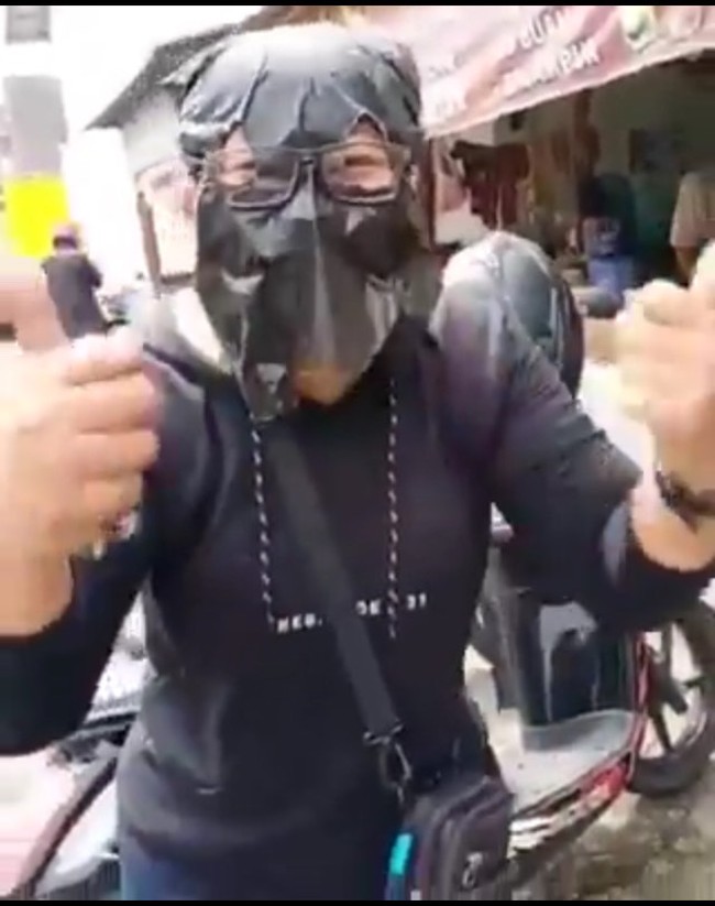 Orang-orang Indonesia memang cukup kreatif dalam memanfaatkan barang. Seperti yang dilakukan oleh wanita ini yang kehabisan masker medis dan memilih menggunakan masker dari plastik hitam untuk menangkal virus Corona. Foto: Istimewa