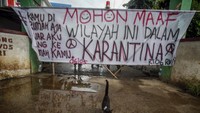 Spanduk karantina wilayah terpasang di Kampung Cikempong, Cibinong, Kabupaten Bogor, Jawa Barat, Senin (6/4/2020). Warga kampung tersebut memberlakukan karantina wilayah secara mandiri dengan menutup sementara akses jalan masuk ke perkampungan mereka sebagai upaya mencegah penyebaran COVID-19. Foto: ANTARA FOTO/Yulius Satria Wijaya
