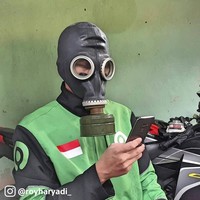 Abang ojol ini memproteksi dirinya dari penyebaran virus Corona dengan menggunakan masker tak biasa. Ya, masker radiasi.Foto: Istimewa