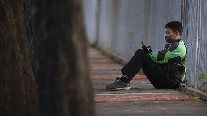 Ketika Ojol Lelah Menanti Penumpang Sejak imbauan pemerintah untuk melakukan jaga jarak fisik terkait COVID-19, pendapatan para pengemudi ojek daring turun drastis. Kini penumpang kian sepi.