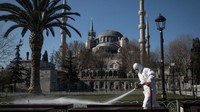 Seorang karyawan dari Kota Istanbul membersihkan dan mendisinfeksi area di depan Masjid Biru Istanbul, Turki. Getty Images/Chris McGrath.
