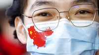 Seorang wanita memakai masker  berlambang peta negara China.
