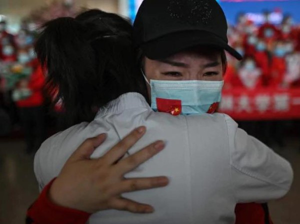 Anggota staf medis Provinsi Jilin menangis saat memeluk perawat dari Wuhan setelah lockdown berakhir. (AFP) Anggota staf medis Provinsi Jilin menangis saat memeluk perawat dari Wuhan setelah lockdown berakhir. (AFP)