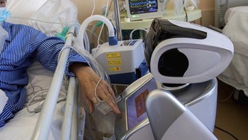 Paramedis menjaga jarak sementara robot dapat berinteraksi langsung dengan pasien diRS Ospedale Circolo, Italia (8/4/2020). 6 unit robot diterjunkan di rumah sakit ini untuk membantu kerja paramedis merawat pasien COVID-19. AP/Luca Bruno