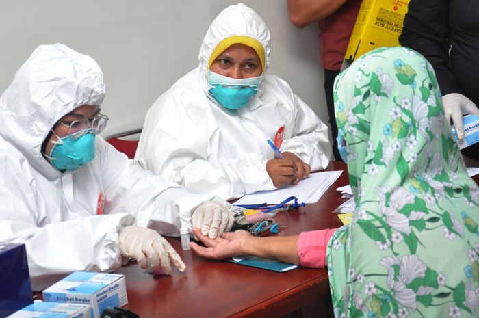 RAPID TEST TKI DARI MALAYSIA Seorang Tenaga Kerja Indonesia (TKI) mengikuti Rapid Test COVID-19 ketika tiba dari Malaysia di Bandara Internasional Kualanamu Kabupaten Deliserdang, Sumatera Utara, Kamis (9/4/2020). Sebanyak 134 orang TKI yang terdampak 'lockdown' atau karantina wilayah COVID-19 dari Malaysia yang pulang melalui bandara Kualanamu tersebut menjalani Rapid Test untuk mengantisipasi pencegahan penyebaran COVID-19 sebelum kembali mengikuti proses karantina. ANTARA FOTO/Septianda Perdana/nz