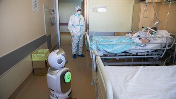 Robot berinteraksi dengan pasien di RS Ospedale Circolo, Italia (8/4/2020).6 unit robot diterjunkan di rumah sakit ini untuk membantu kerja paramedis merawat pasien COVID-19. AP Photo/Luca Bruno