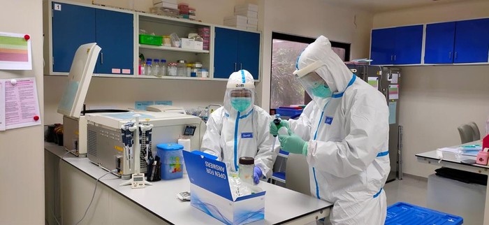 Petugas ber-APD melakukan uji PCR Corona di lab UGM