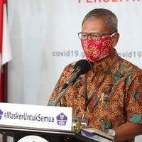 Tampak pria 58 tahun itu memakai masker berwarna oranye yang mirip di logo BNPB. Masker yang sama juga dipakai beberapa pria yang ikut mendampingi Achmad Yurianto di kesempatan tersebut. Hari-hari berikutnya, masker kain pilihan Achmad Yurianto seolah menjelma sebagai aksesori dengan fashion statement tersendiri.Masker yang dipakainya sesekali matching dengan baju batiknya. Pernah ia memakai masker bermotif batik nuansa floral dengan warna merah muda keunguan sebagai dasarnya. (Foto: dok. BNPB)