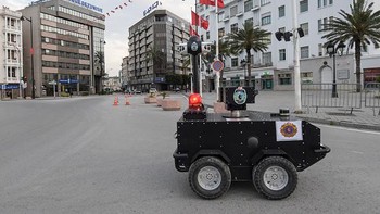  Polisi Tunisia menurunkan robot patrolinya seperti terlihat di LapanganHabib Bourguiba, Tunis (1/4/2020).  Robot tersebut diberi kemampuan mendeteksi suhu tubuh, suara dan lampu alarm. FETHI BELAID/AFP via Getty Images