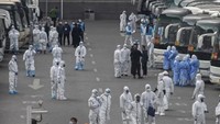 Para pelancong dari Wuhan berkumpul untuk naik bis saat mereka tiba di Beijing untuk melakukan karantina selama 14 hari. (AFP)