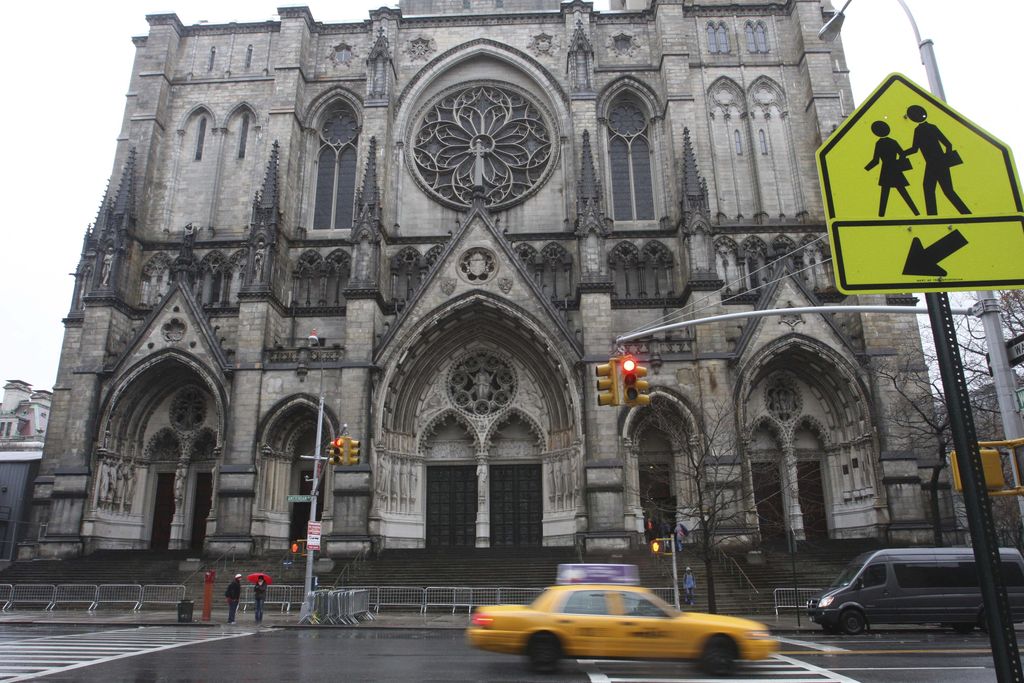 FILE- In this Nov. 30, 2008 file photo, a taxi drives past the Cathedral of St. John the Divine in New York. The cavernous cathedral that normally would be hosting prayer services in preparation for Easter may instead spend Holy Week being outfitted as a field hospital to help with the coronavirus pandemic. (AP Photo/Tina Fineberg, File)
