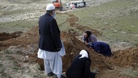 Beberapa warga menangis di makam kerabatnya yang meninggal akibat virus Corona (COVID-19) di Provinsi Herat, Afghanistan. AP Photo/Hamed Sarfarazi.