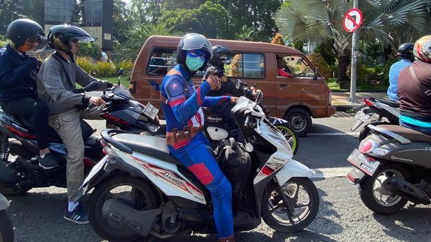 Wow, ada 'Captain America' berkeliling Surabaya. Ia mengendarai motor matic untuk mengingatkan semua orang akan pentingnya menggunakan masker di luar rumah saat pandemi Corona.