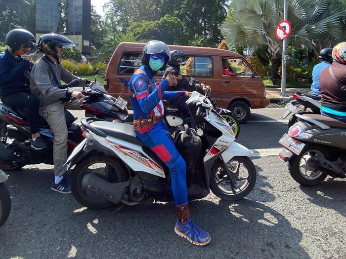 Wow, ada Captain America berkeliling Surabaya. Ia mengendarai motor matic untuk mengingatkan semua orang akan pentingnya menggunakan masker di luar rumah saat pandemi Corona.