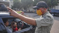 Petugas Satpol PP memberhentikan pengendara mobil yang tidak memakai masker di Perbatasan Bekasi menuju Jakarta di Pondok Gede. ANTARA FOTO/ Fakhri Hermansyah.