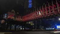 Selain itu, Jembatan Penyeberangan Orang (JPO) di Polda Metro Jaya juga hanya menampilkan warna merah putih, Kamis (9/4/2020) malam. Biasanya JPO ini menampilkan warna warni yang indah.