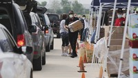 Relawan mendistribusikan makanan kepada warga.