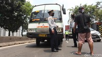 Petugas Dishub menghentikan sopir kopaja dengan jurusan Taman Anggrek-Cengkareng yang telah habis masa trayek di Daan Mogot, Jakarta Barat, Jumat (10/4/2020).