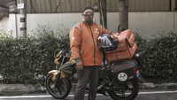 Rohaizat, seorang pekerja layanan pengiriman berpose untuk potret saat dia beristirahat.