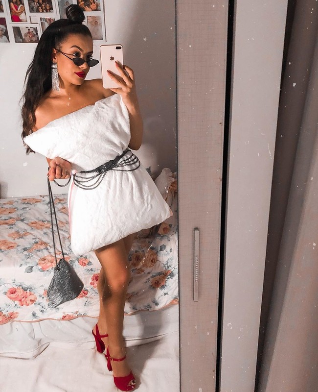 Tengok saja gaya Anna Cruz, seorang selebgram fashion asal Brasil ini. Memakai bantal putih, ia menyempurnakan gayanya dengan statement earring, tas bling-bling, kacamata hitam bergaya vintage dan chunky peep toe heels merah. Penampilannya sudah cocok untuk pesta. (Foto: Instagram)