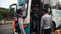 Petugas juga turut memeriksa bus yang hendak masuk ke gerbang Tol Tanjung Priok 1, Jakarta Utara.