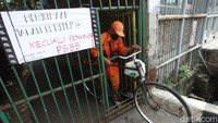 Seorang petugas PPSU keluar dari salah satu gang yang juga di lockdown oleh warganya.