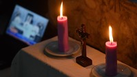 Melalui televisi atau ponsel, Umat Katolik tetap melaksanakan Kamis Putih dengan khidmat, seperti di Jawa Timur ini. ANTARA FOTO/Zabur Karuru  