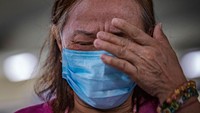 Seorang wanita tunawisma menangis ketika seorang pendeta Katolik mencuci kakinya sebagai bagian dari ritual Kamis Putih. Ezra Acayan/Getty Images.