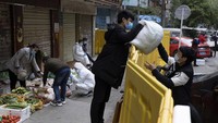 Beberapa alat penghalang di Wuhan masih belum dibongkar, namun para penjual sayur dan makanan mulai kembali membuka lapak mereka di pinggir jalan. Foto: Istimewa