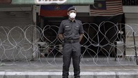 Nezzwan, anggota Pasukan Kepolisian Kerajaan Malaysia berpose untuk potret ketika ia menjaga pintu masuk ke sebuah flat yang diidentifikasi sebagai area berisiko tinggi COVID-19.
