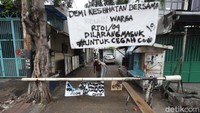 Sebuah portal juga tertutup dan banner besar terpampang di gerbang masuk gang di kawasan Jakarta Barat.