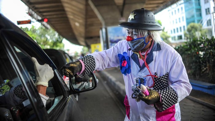 Anggota Perkumpulan Badut Jawa Barat (PBJB) membagikan masker di Pasteur, Bandung, Jawa Barat, Sabtu (11/4/2020). PBJB membagikan 1.000 masker kepada pengendara sebagai aksi kepedulian pada masyarakat agar tidak terpapar COVID-19. ANTARA FOTO/Raisan Al Farisi/hp.