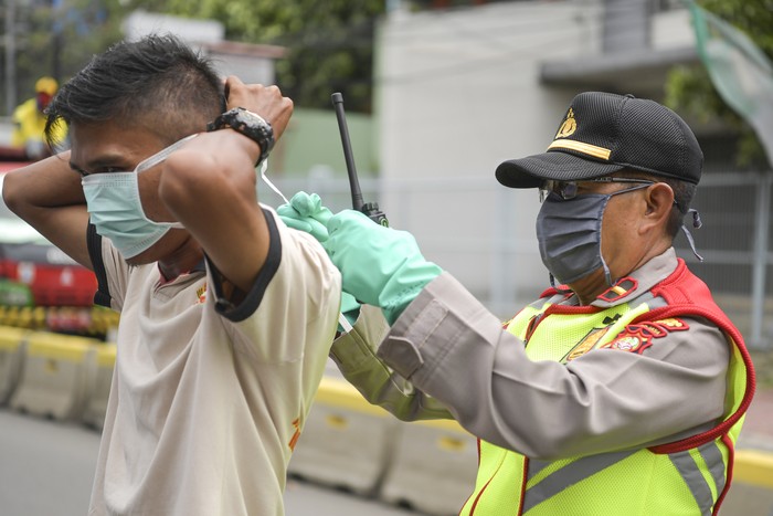 Polisi melakukan imbauan kepada pengendara mobil untuk dapat mematuhi penerapan Pembatasan Sosial Berskala Besar (PSBB) di kawasan Menteng, Jakarta (11/4/2020). Iimbauan ini dilakukan agar masyarakat menerapkan pembatasan sosial berskala besar (PSBB) selama 14 hari, yang salah satu aturannya adalah pembatasan penumpang kendaraan serta anjuran untuk menggunakan masker jika berkendara. ANTARA FOTO/Nova Wahyudi/hp.