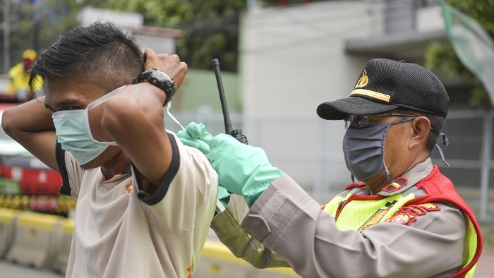 Polisi melakukan imbauan kepada pengendara mobil untuk dapat mematuhi penerapan Pembatasan Sosial Berskala Besar (PSBB) di kawasan Menteng, Jakarta (11/4/2020). Iimbauan ini dilakukan agar masyarakat menerapkan pembatasan sosial berskala besar (PSBB) selama 14 hari, yang salah satu aturannya adalah pembatasan penumpang kendaraan serta anjuran untuk menggunakan masker jika berkendara. ANTARA FOTO/Nova Wahyudi/hp.