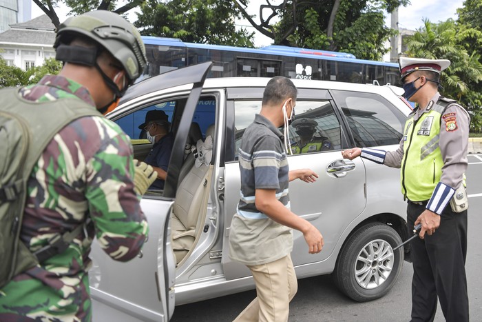 Polisi melakukan imbauan kepada pengendara mobil untuk dapat mematuhi penerapan Pembatasan Sosial Berskala Besar (PSBB) di kawasan Menteng, Jakarta (11/4/2020). Iimbauan ini dilakukan agar masyarakat menerapkan pembatasan sosial berskala besar (PSBB) selama 14 hari, yang salah satu aturannya adalah pembatasan penumpang kendaraan serta anjuran untuk menggunakan masker jika berkendara. ANTARA FOTO/Nova Wahyudi/hp.