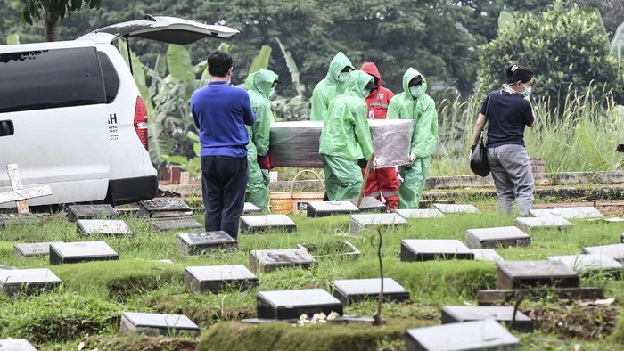 Petugas pemakaman membawa peti jenazah pasien COVID-19 di TPU Pondok Ranggon, Jakarta, Senin (30/3/2020). Juru bicara pemerintah untuk penanganan COVID-19 Achmad Yurianto per Senin (30/3/2020) pukul 12.00 WIB menyatakan jumlah pasien positif COVID-19 di Indonesia telah mencapai 1.414  kasus, pasien yang telah dinyatakan sembuh sebanyak 75 orang, sementara kasus kematian bertambah delapan orang dari sebelumnya 114 orang menjadi 122 orang.