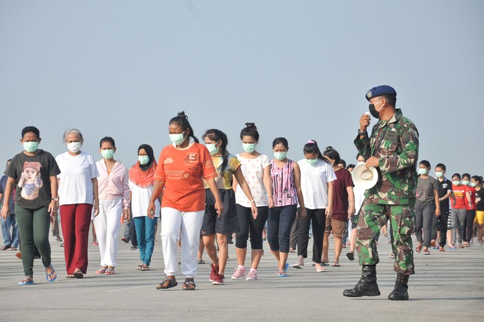 KARANTINA COVID-19 TKI ASAL MALAYSIA Sejumlah Tenaga Kerja Indonesia (TKI) asal Malaysia mengikuti senam dan berjemur di bawah sinar matahari saat menjalani karantina di Pangkalan Udara Militer (Lanud) Soewondo Medan, Sumatera Utara, Sabtu (11/4/2020). Sebanyak 513 TKI yang berasal dari berbagai daerah di Sumut dan sekitarnya yang menjalani proses karantina COVID-19 sementara tersebut saat ini kondisi kesehatannya baik dan tidak ada menunjukan gejala infeksi seperti demam, batuk dan sesak nafas. ANTARA FOTO/Septianda Perdana/hp.
