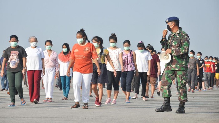 Sejumlah Tenaga Kerja Indonesia (TKI) asal Malaysia mengikuti senam dan berjemur di bawah sinar matahari saat menjalani karantina di Pangkalan Udara Militer (Lanud) Soewondo Medan, Sumatera Utara, Sabtu (11/4/2020). Sebanyak 513 TKI yang berasal dari berbagai daerah di Sumut dan sekitarnya yang menjalani proses karantina COVID-19 sementara tersebut saat ini kondisi kesehatannya baik dan tidak ada menunjukan gejala infeksi seperti demam, batuk dan sesak nafas. ANTARA FOTO/Septianda Perdana/hp.