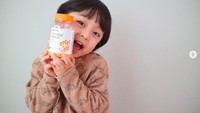 Pose dengan vitamin jelly rasa jeruk, Woo Jin terlihat luwes di depan kamera. Ia pintar memamerkan banyak gaya lho! Foto: Instagram _angel_elijah_