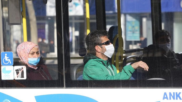 People wear protective masks look on in a bus in Ankara, on April 6, 2020, as a partial curfew for the citizens older than 65, under 20 and those who have chronic conditions have been imposed in Turkey against the spread of the COVID-19 caused by the novel coronavirus. (Photo by Adem ALTAN / AFP)