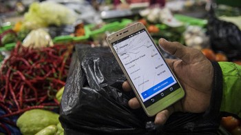 Pedagang menyerahkan pesanan sayur-mayur kepada pengemudi daring di pasar Kosambi, Bandung, Jawa Barat. Antara Foto/M Agung Rajasa.