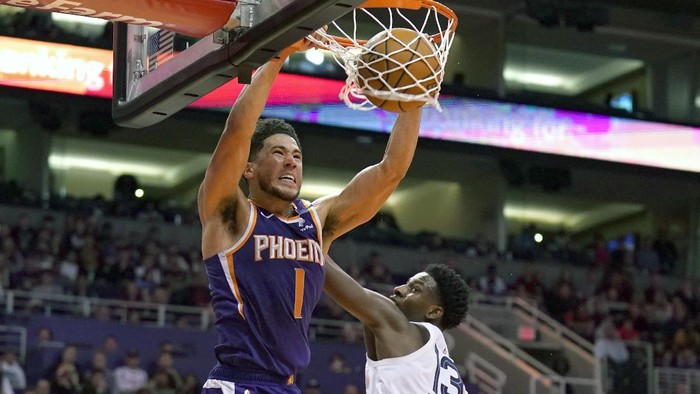 FILE - In this Jan. 5, 2020, file photo, Phoenix Suns guard Devin Booker (1) dunks over Memphis Grizzlies forward Jaren Jackson Jr. in the second half of an NBA basketball game in Phoenix. Booker won the NBA 2K20 Players Tournament on Saturday, April 11, 2020, sweeping Suns teammate Deandre Ayton in the best-of-three final. (AP Photo/Rick Scuteri, File)