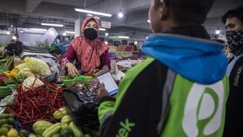 Seorang pedagang sedang mengemas pesanan daring sayur-mayur di pasar Kosambi, Bandung, Jawa Barat. Antara Foto/M Agung Rajasa. 