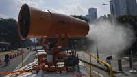 Petugas gabungan dari TNI dan Palang Merah Indonesia (PMI) melakukan penyemprotan cairan disinfektan dengan menggunakan mobil gunners spraying di Jalan Jenderal Sudirman, Jakarta, Minggu (12/4/2020). 