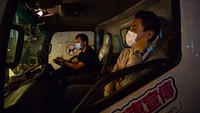 Seorang guru musik tampak menggunakan masker saat menaiki truk yang dirombak menjadi tempat les piano keliling untuk menuju ke tempat tinggal salah satu muridnya yang akan berlatih piano di dalam truk tersebut